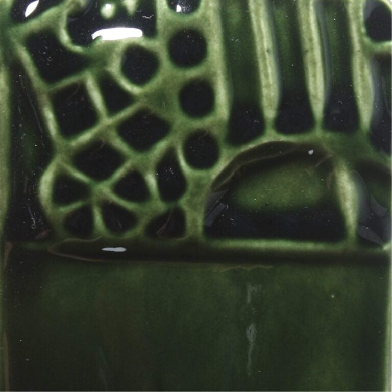 Green ceramic tile with decorative, textured pattern and glossy finish