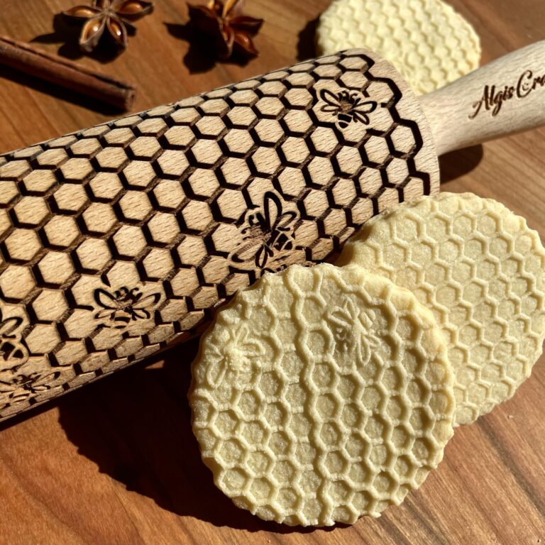 Honeycomb-patterned rolling pin and cookies with spices on a wooden surface